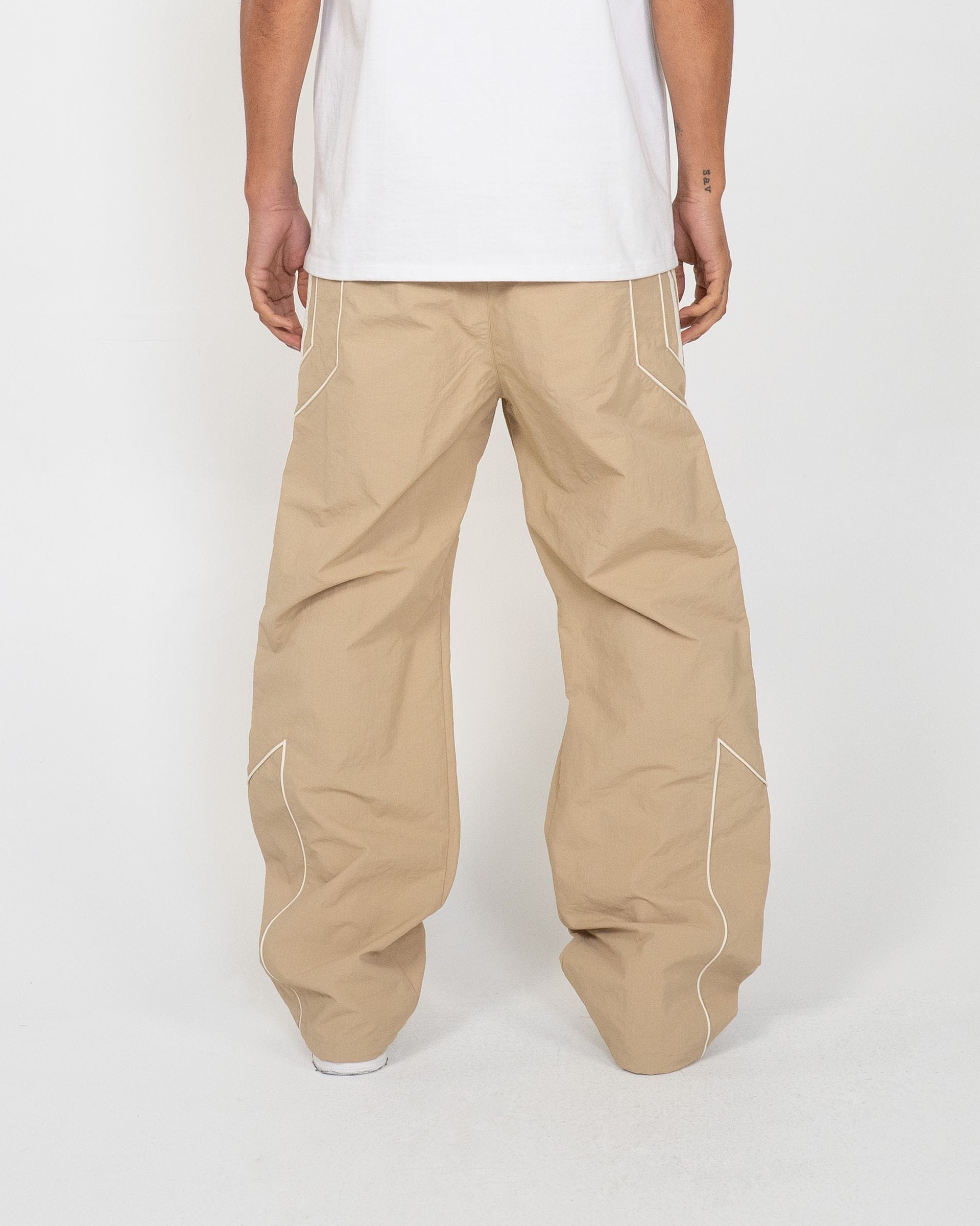 EPTM Pepe track pants featuring a relaxed fit, black color, and elastic waistband, shown on a model.