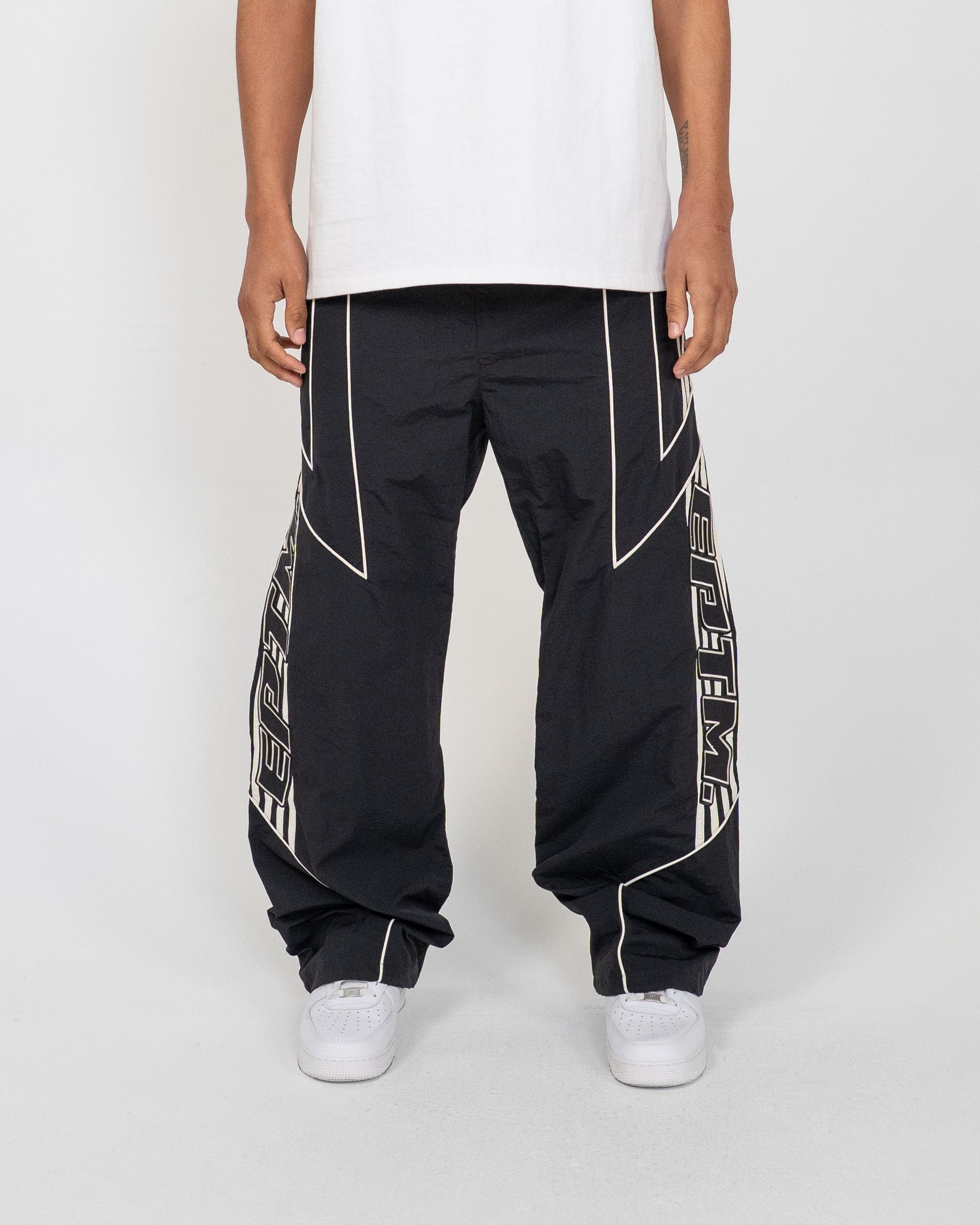 EPTM Pepe track pants shown in black with white side stripe, made from comfortable athletic fabric for casual and sportswear.