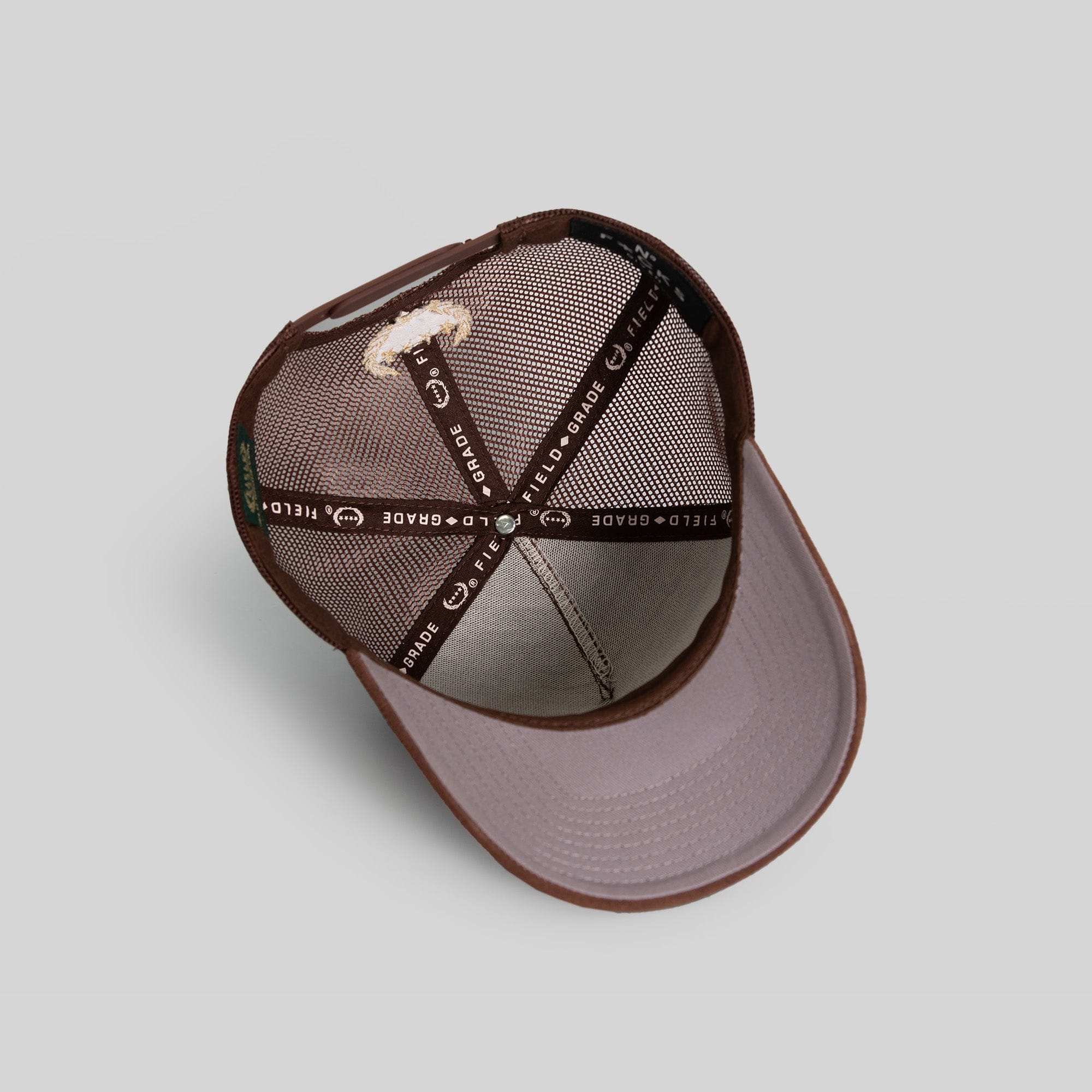 Field Grade No F*cks Given mocha suede mesh trucker hat with embroidered logo and adjustable snapback closure.