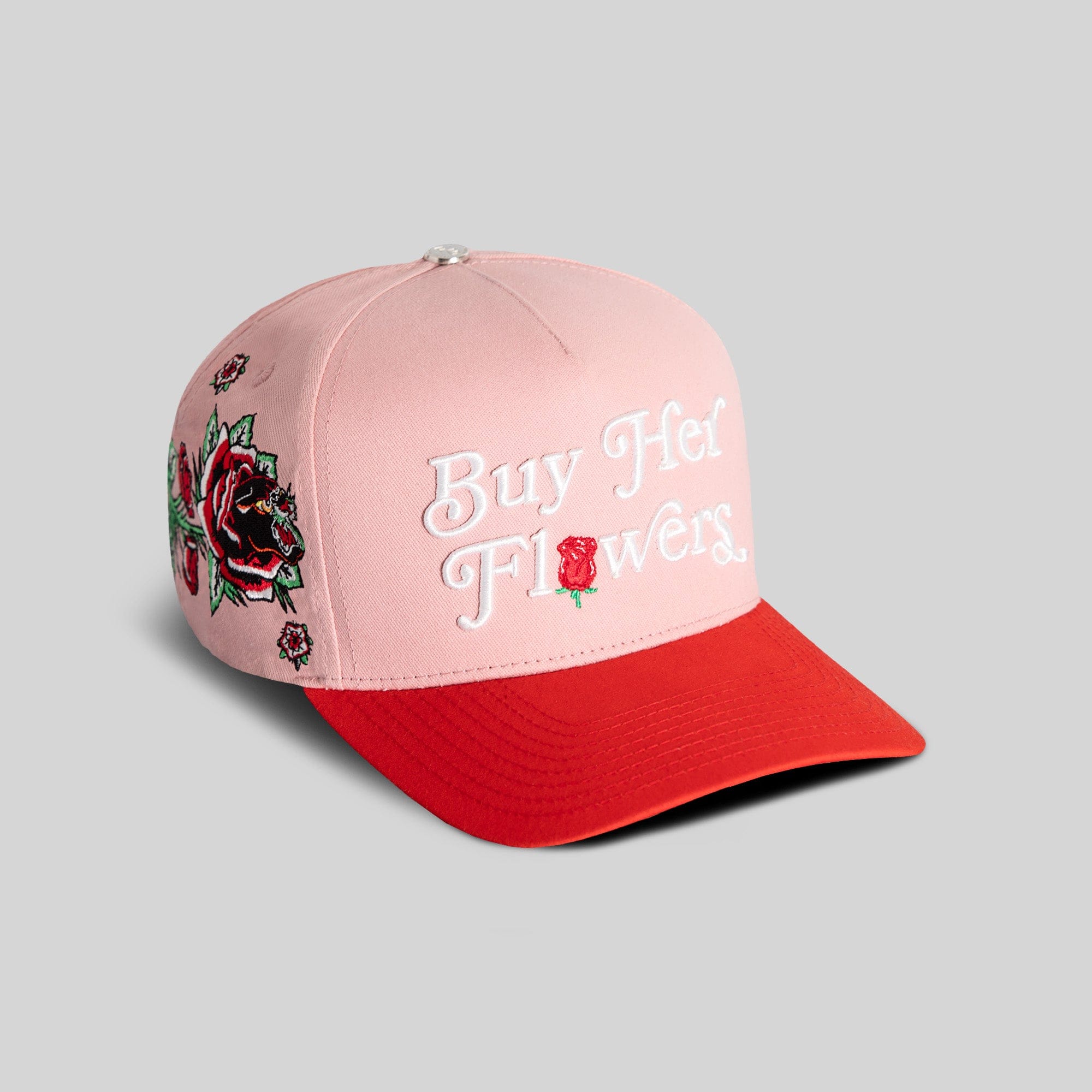 Pink twill trucker hat from Field Grade's Buy Her Flowers Rose Royce collection with embroidered floral design and adjustable strap.