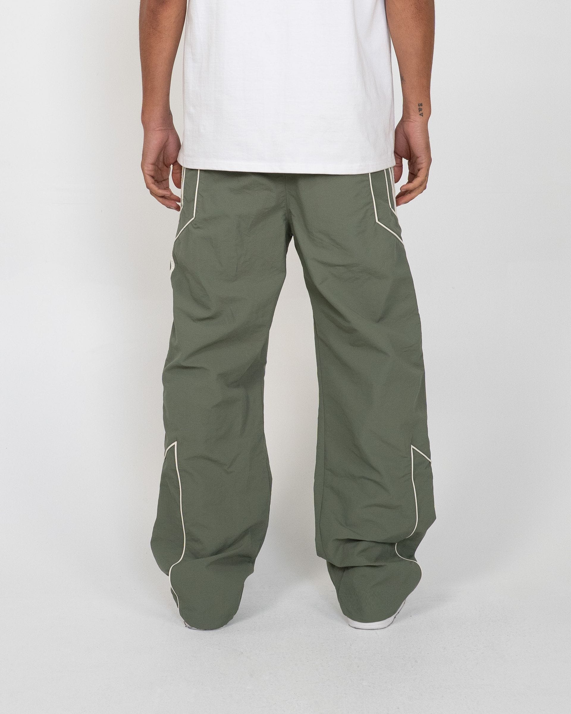 EPTM Pepe track pants in black with white logo, featuring a relaxed fit and elastic waistband, shown on a hanger.