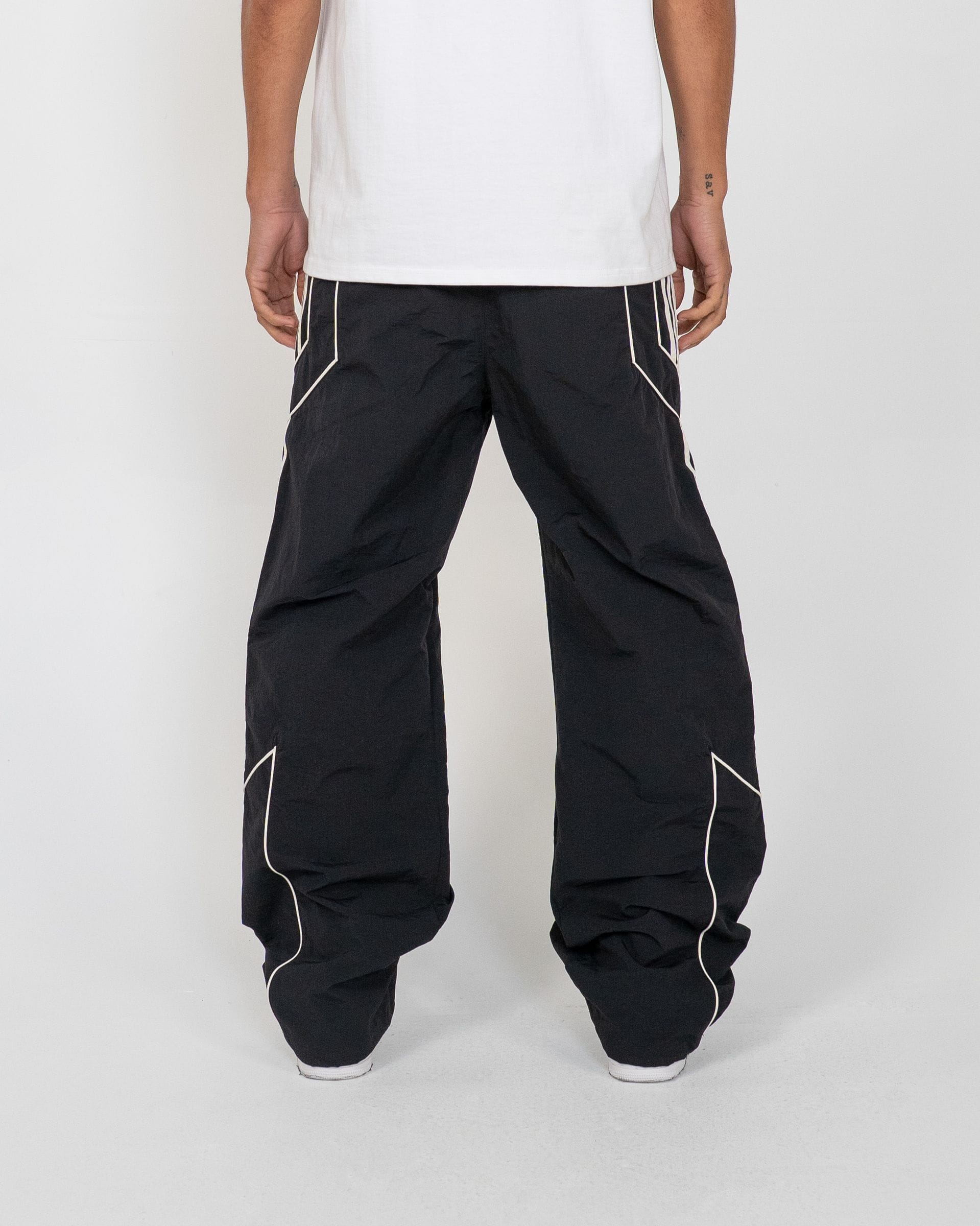 EPTM Pepe track pants in black, featuring a slim fit design and elastic waistband, shown on a model.