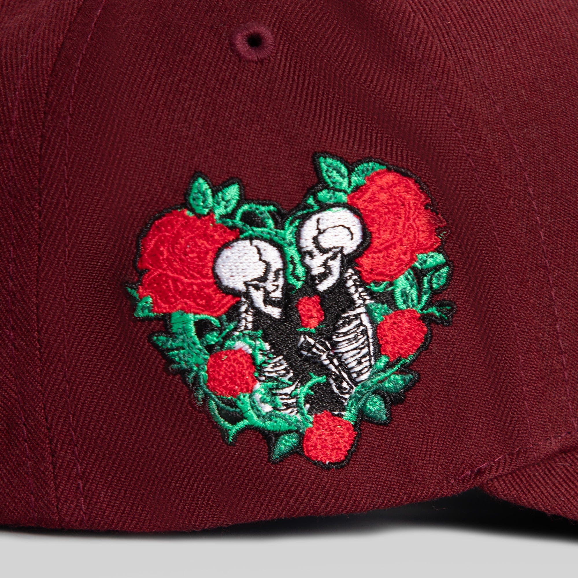 Field Grade Buy Her Flowers Bordeaux wool trucker hat with a curved brim and adjustable strap, shown from a front angle.