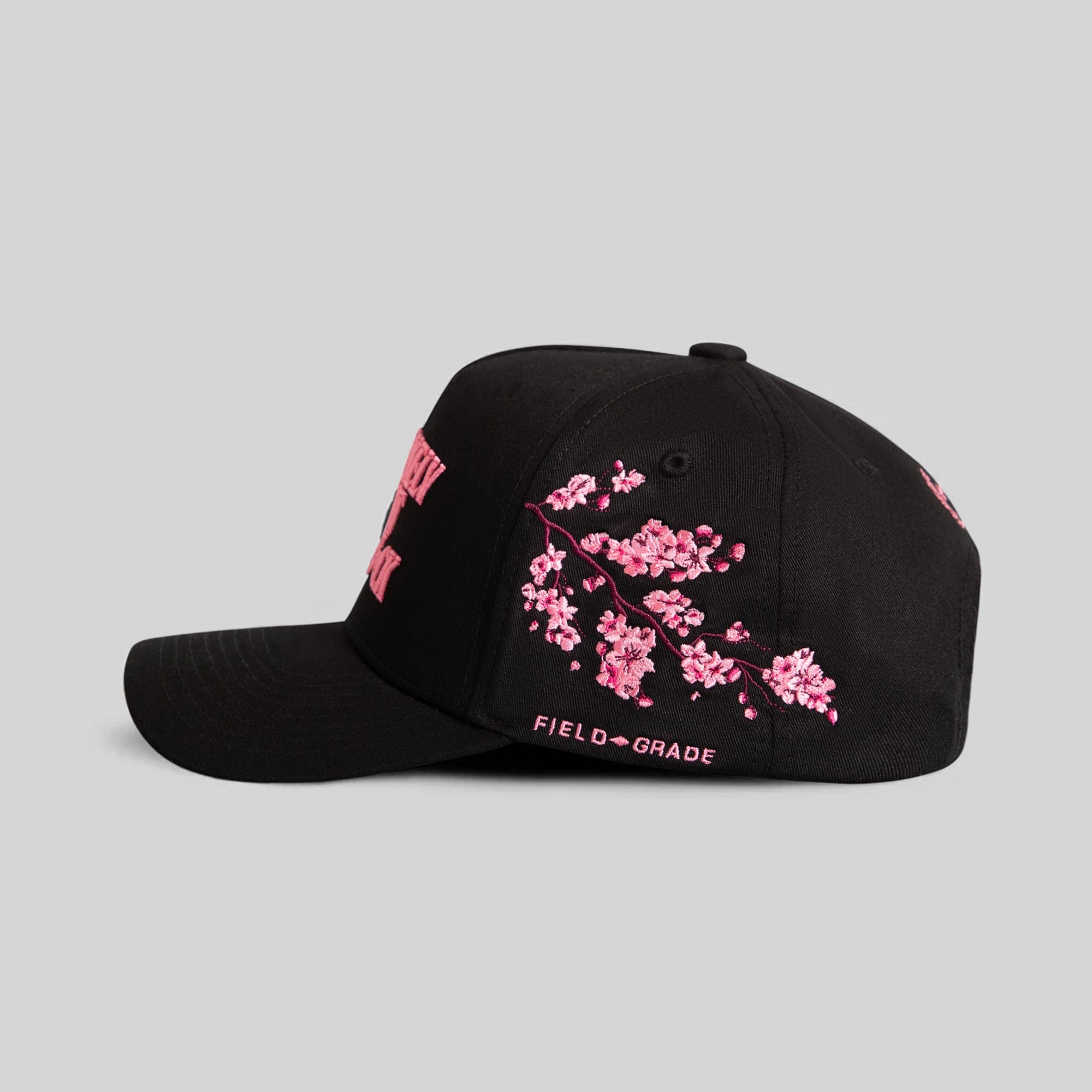 Field Grade Most Likely Cherry Blossom black twill trucker hat with adjustable snapback and embroidered cherry blossom design.