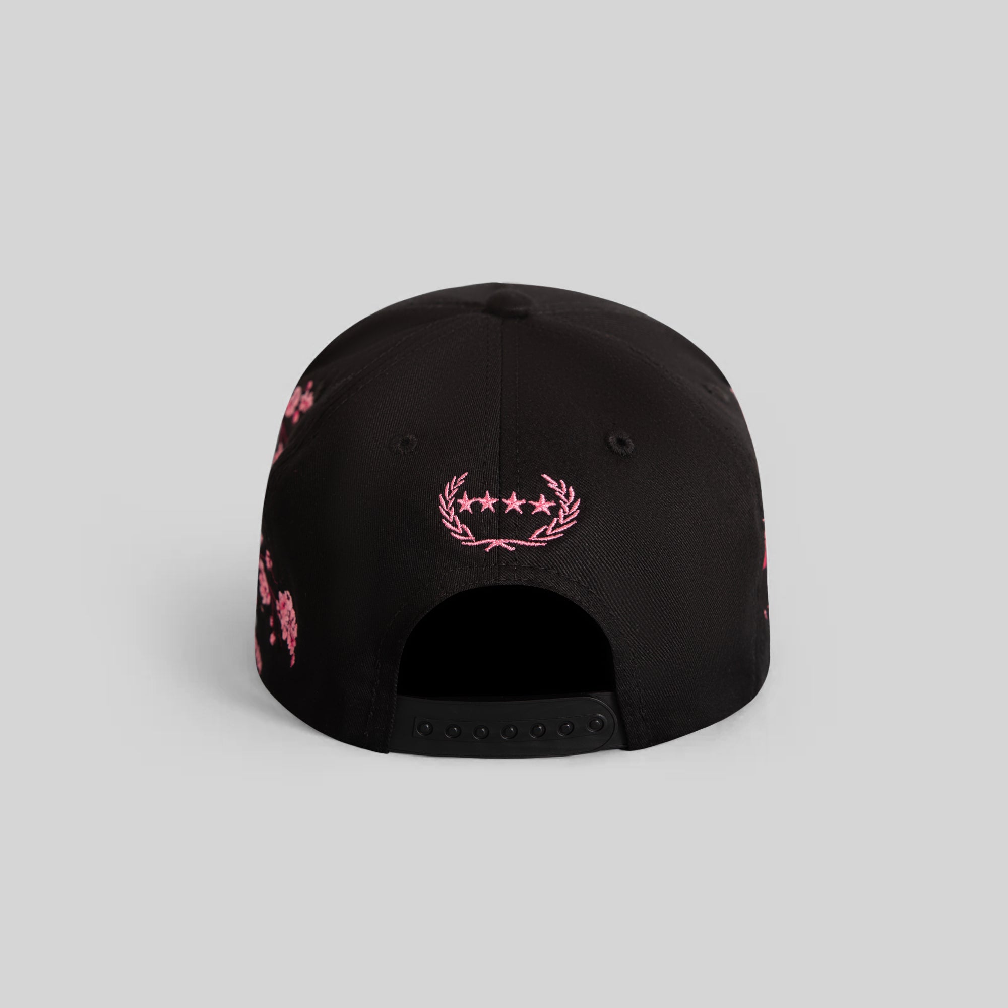 Field Grade cherry blossom black twill trucker hat with adjustable snapback and embroidered front logo.